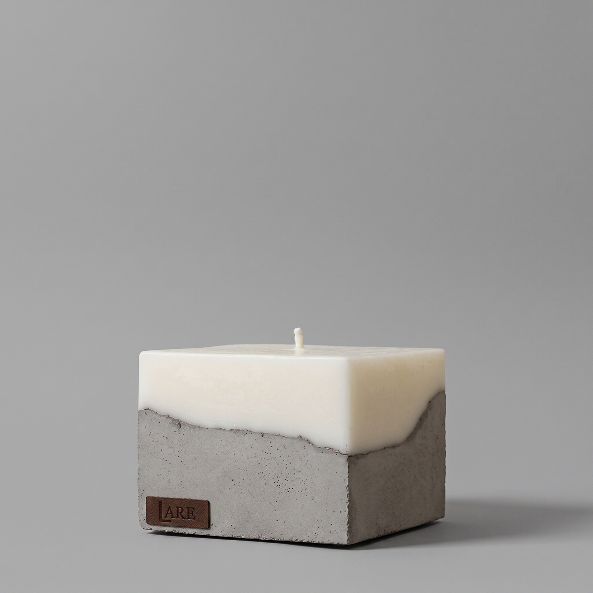 LARE Studio square concrete candle with soy wax and a single cotton wick, designed as one of the environmentally friendly candles for stylish, sustainable-inspired interiors, on a neutral grey background.