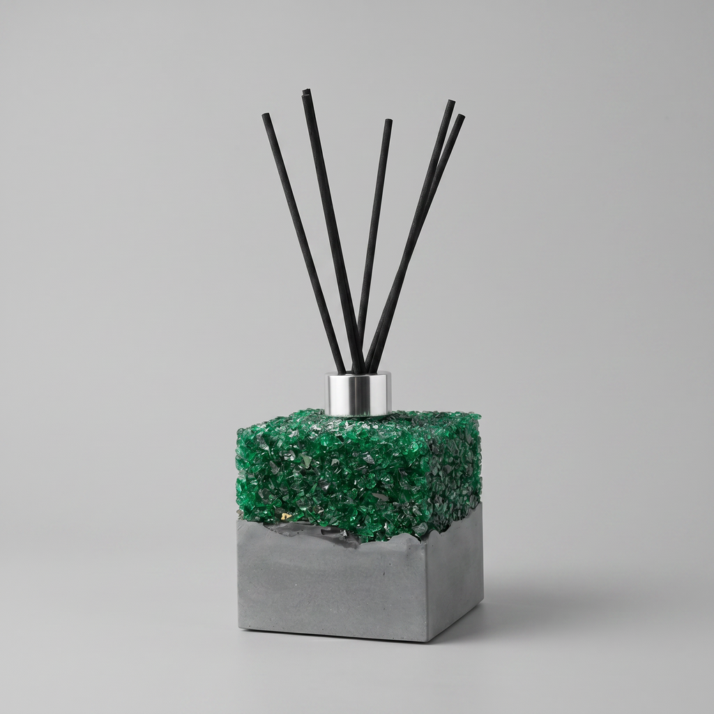 Reed diffuser with green decorative stones and black sticks on a gray background