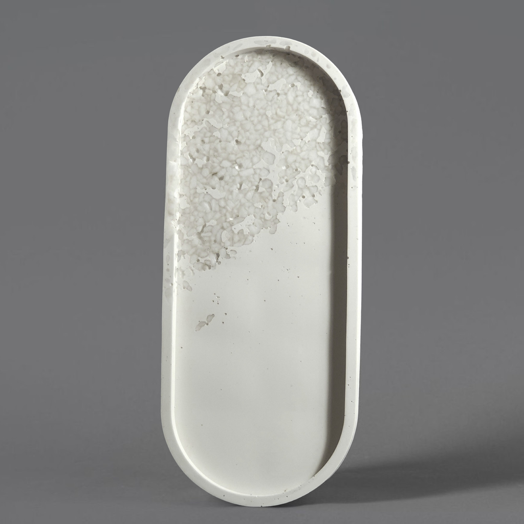 Oval-shaped jesmonite tray with textured surface on a gray background