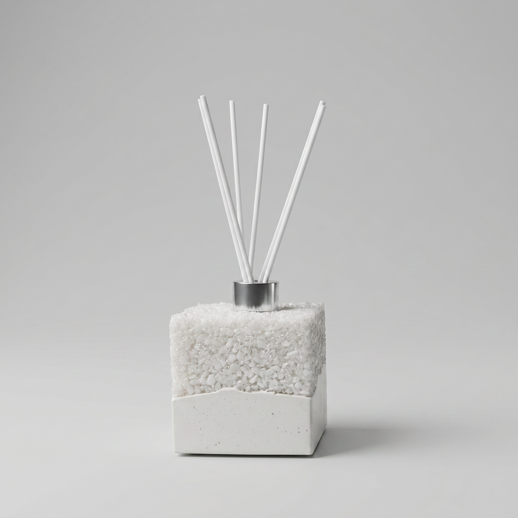 Handmade jesmonite and resin diffuser with white reeds on a gray background