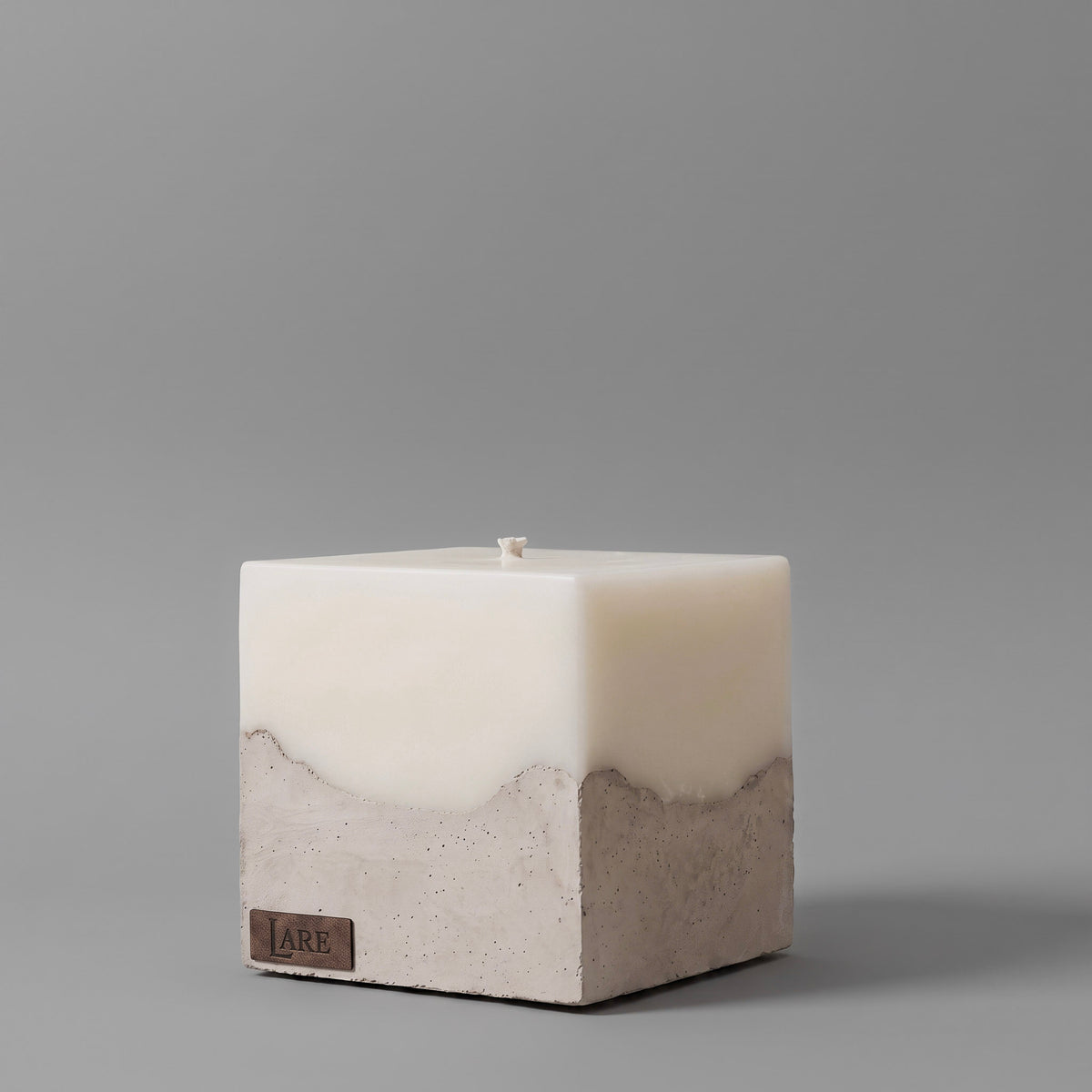 Sculptural beige candle by LARE Studio with a stone-like concrete base and premium candle natural wax for a clean scent from candles.