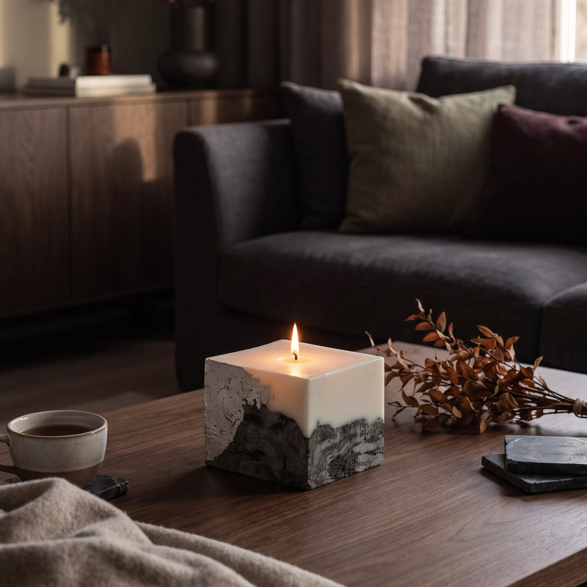 LARE candles that burn clean — soy wax candle with concrete marble-like base on a wooden coffee table in a cozy autumn living room
