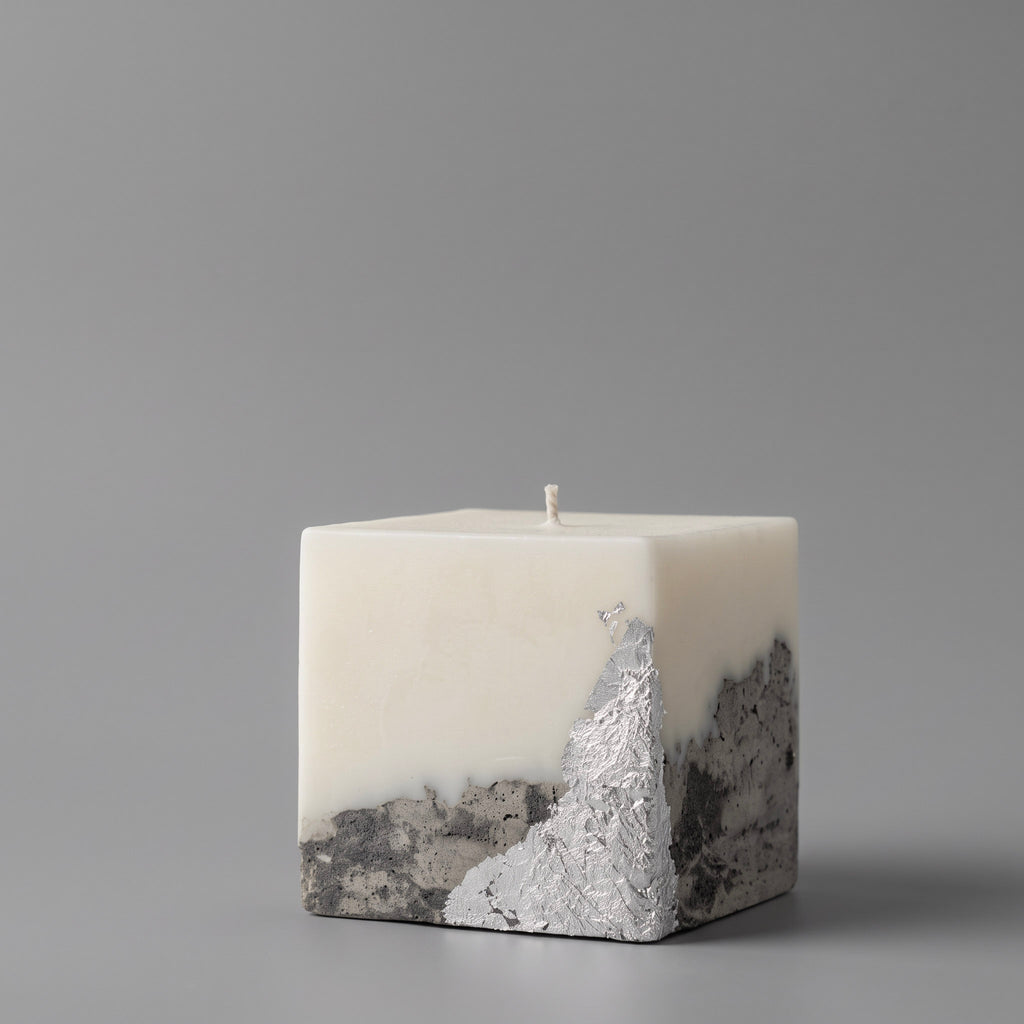 Handmade candle by LARE — square soy wax with textured silver metallic concrete base, set against a gray background