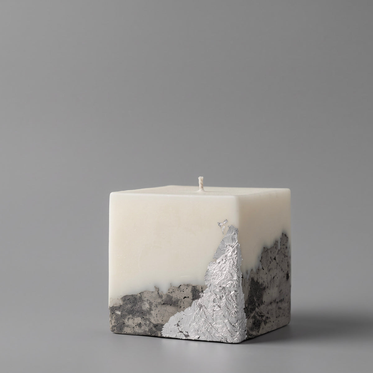 Handmade candle by LARE — square soy wax with textured silver metallic concrete base, set against a gray background