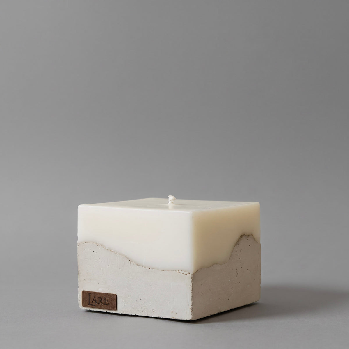 A modern beige candle crafted from high-quality candle natural wax, featured among premium home fragrance products, releasing a luxury scent from candles, on a grey background.