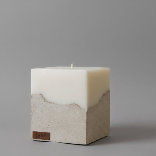 Sculptural beige candle by LARE Studio with a stone-like concrete base, designed to diffuse a luxury scent from candles.