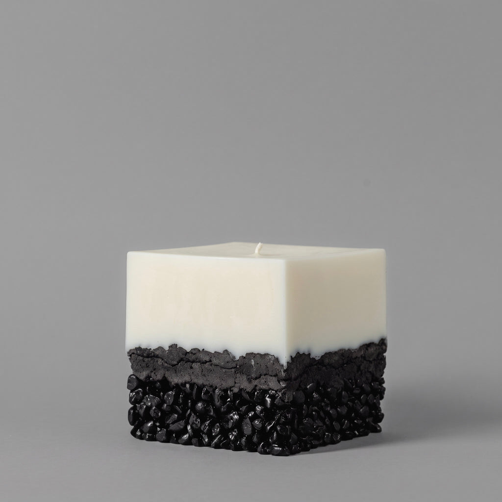 LARE Studio soy candle made with soybean wax for candles, featuring a smooth white top and textured black pebble-effect base on a gray studio background.