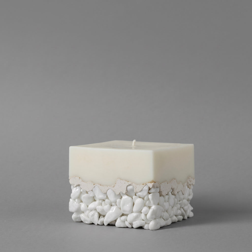 LARE best candles — white sculptural luxury candle with pebble base, unique candles for modern home decor. Photographed against a solid gray studio background.