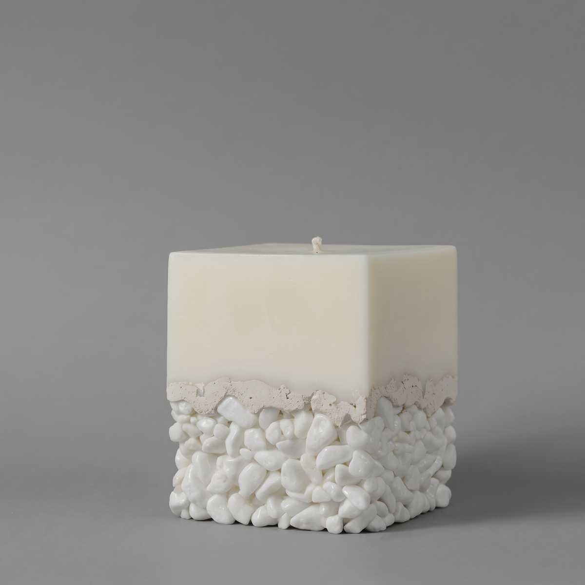 LARE unique candle — white sculptural soy candle wax with pebble and cement base and premium candle scent oil. Photographed against a neutral gray background.